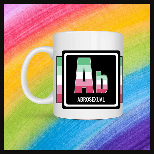 White mug with a 3 inch square containing the element’s symbol (Ab) and name (Abrosexual). Symbol is made with the colors of that element’s flag on a black background. The pride flag is displayed behind the symbol. Behind the mug is a rainbow background.