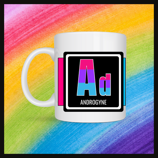 White mug with a 3 inch square containing the element’s symbol (Ad) and name (Androgyne). Symbol is made with the colors of that element’s flag on a black background. Behind the keychain is a rainbow background.