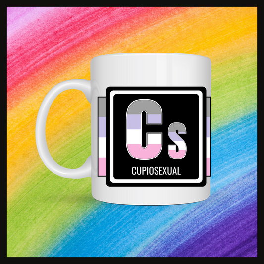 White mug with a 3 inch square containing the element’s symbol (Cs) and name (Cupiosexual). Symbol is made with the colors of that element’s flag on a black background. Behind the mug is a rainbow background.
