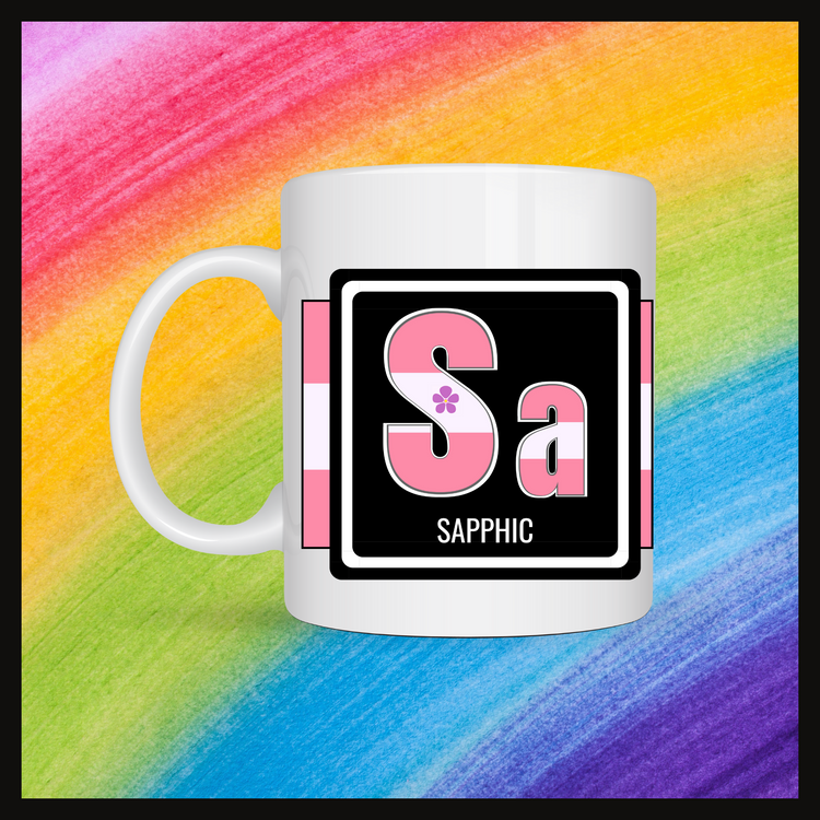 White mug with a 3 inch square containing the element’s symbol (Sa) and name (Sapphic). Symbol is made with the colors of that element’s flag in a black square with the element’s flag behind the square. Behind the mug is a rainbow background.