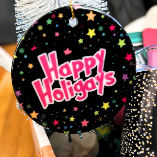 A Happy Holigays ornamennt. Black background and multi-colored stars