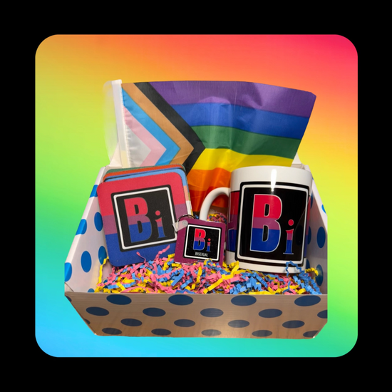 This is our Bisexual Element Gift Box - on a rainbow background inside a dotted blue box that holds a Queer Element Mug, Keychain and a set of our LGBTQ Coasters