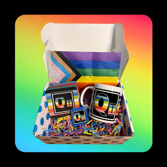 This is our Queer Element Gift Box - on a rainbow background inside a dotted blue box that holds a Queer Element Mug, Keychain and a set of our LGBTQ Coasters