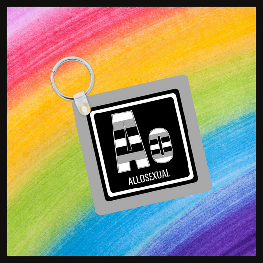 Keychain with the  element symbol (Ao) and name (Allosexual) with a design based on the colors of that element’s flag in a black square with a gray background. Behind the keychain is a rainbow background.