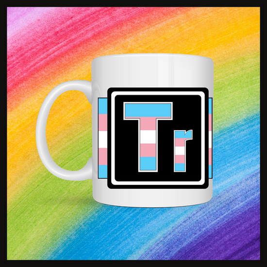 White mug with a 3 inch square containing the element’s symbol (Tr). Symbol is made with the colors of that element’s flag in a black square with the element’s flag behind the square. Behind the mug is a rainbow background.