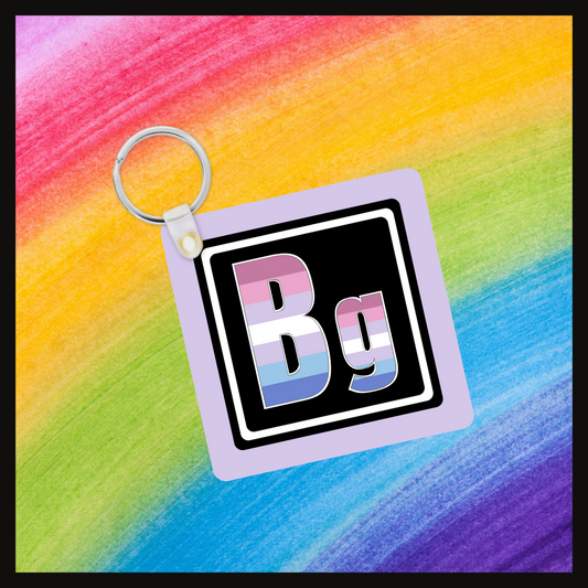 Keychain with the element symbol (Bg) with a design based on the colors of that element’s flag in a black square with a lavender background. Behind the keychain is a rainbow background.