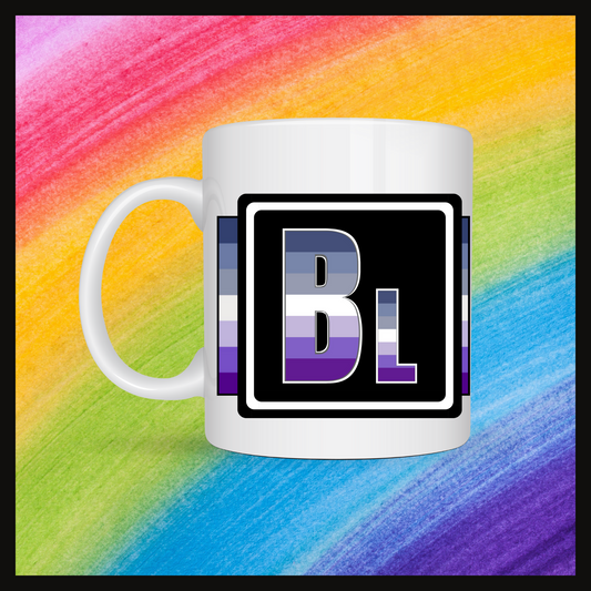White mug with a 3 inch square containing the element’s symbol (Bl). Symbol is made with the colors of that element’s flag in a black square with the element’s flag behind the square. Behind the mug is a rainbow background.