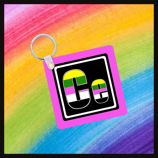 Keychain with the element symbol (Ce) with a design based on the colors of that element’s flag in a black square with a pink background. Behind the keychain is a rainbow background.