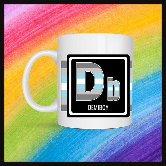 White mug with a 3 inch square containing the element’s symbol (Db) and name (Demiboy). Symbol is made with the colors of that element’s flag in a black square with the element’s flag behind the square. Behind the mug is a rainbow background.