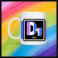 White mug with a 3 inch square containing the element’s symbol (Dg) and name (Drag). Symbol is made with the colors of that element’s flag on a black background. Behind the mug is a rainbow background.