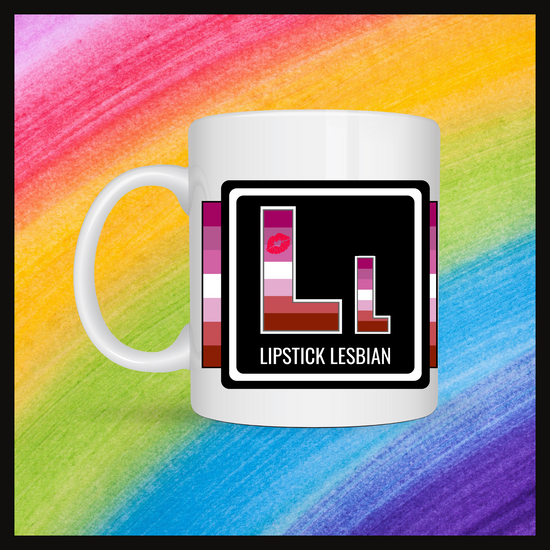 White mug with a 3 inch square containing the element’s symbol (Ll) and name (Lipstick Lesbian). Symbol is made with the colors of that element’s flag in a black square with the element’s flag behind the square. Behind the mug is a rainbow background.