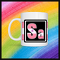 White mug with a 3 inch square containing the element’s symbol (Sa). Symbol is made with the colors of that element’s flag in a black square with the element’s flag behind the square. Behind the mug is a rainbow background.