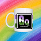 White mug with a 3 inch square containing the element’s symbol (Gq) and name (Genderqueer). ymbol is made with the colors of that element’s flag in a black square with the element’s flag behind the square. Behind the mug is a rainbow background.